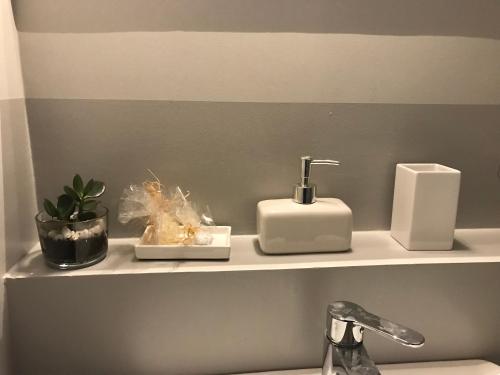 a bathroom shelf with two soap dispensers and a sink at B&B Questa casa non e'un albergo in Palermo