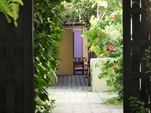 a door leading into a garden with flowers at Pousada O Refúgio in Jericoacoara