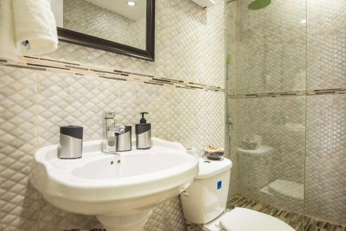 a bathroom with a sink and a toilet and a shower at Turtle Beach Towers in Ocho Rios