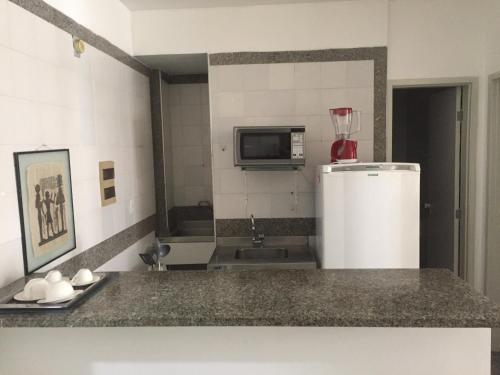 a kitchen with a refrigerator and a microwave at Apartamento New Life in Fortaleza