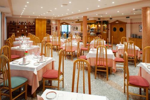 un comedor con mesas y sillas blancas y un restaurante en Hotel Río Cabia, en Cabia