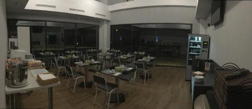 a restaurant with tables and chairs in a room at H La Cabaña in Pozuelo de Alarcón