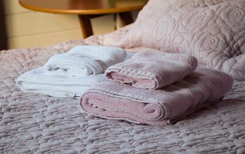 a group of towels sitting on top of a bed at Hospedaria Os Memorialistas - Paranapiacaba in Paranapiacaba