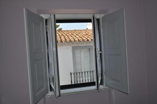 an open window with a view of a roof at A Casa do Mestre in Évora
