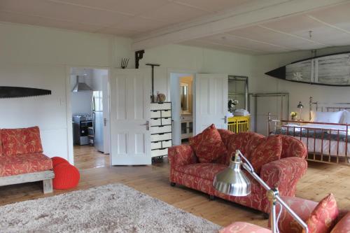 a living room with two red couches and a kitchen at Pirralilla Estate Adelaide Hills in Aldgate
