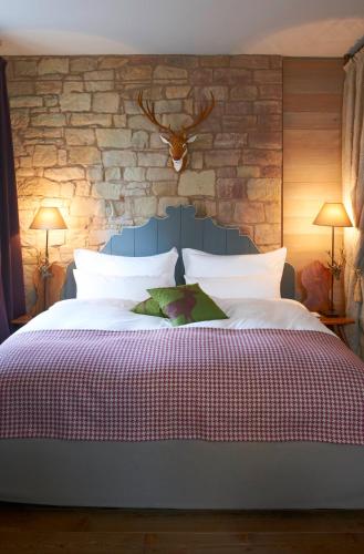 a bedroom with a large bed with a stone wall at Lösch für Freunde in Hornbach