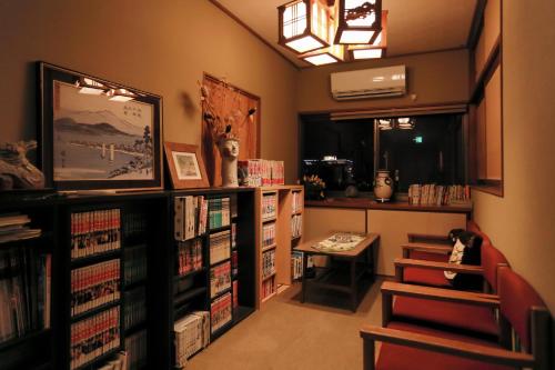 a room with a book shelf filled with books at Jinpuso in Miyazu