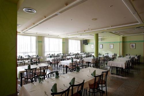 a room filled with tables and chairs with white table cloth at Hotel Río Cabia in Cabia