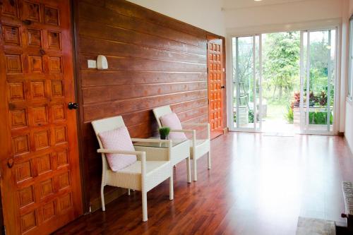 a dining room with two chairs and a glass table at Blue Sky Villa Khao Yai in Pak Chong