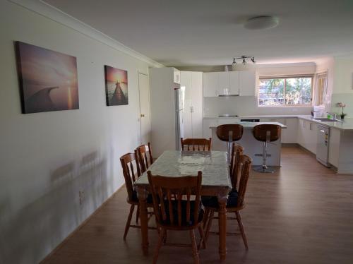 eine Küche und ein Esszimmer mit einem Tisch und Stühlen in der Unterkunft Mountain View Beach House in Catalina