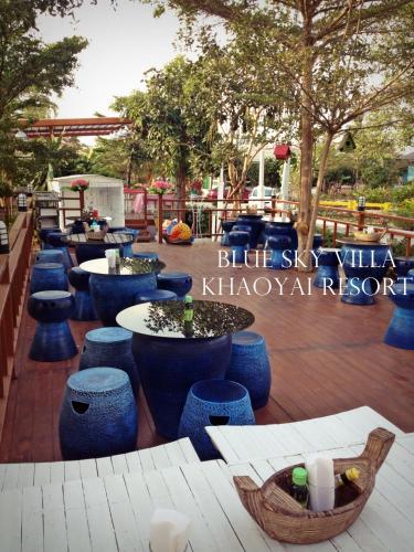 a restaurant with blue stools and tables and trees at Blue Sky Villa Khao Yai in Pak Chong