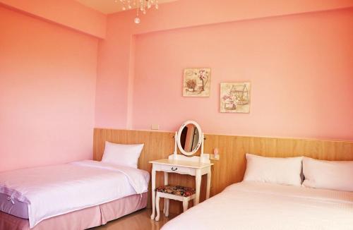 two beds in a room with a mirror at England B&B in Taiping