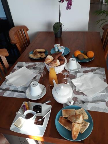 a wooden table with plates of food on it at Villa Belza et SPA in Saint-Pierre