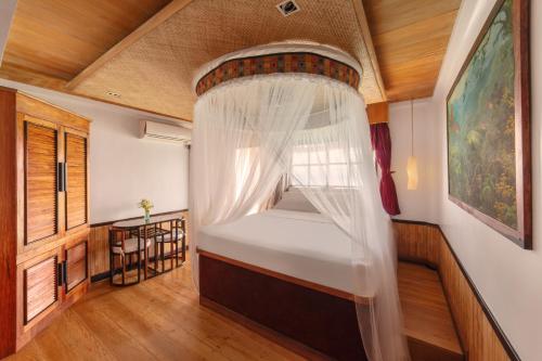 a bedroom with a bed with a canopy at NoaNoa Private Island in Taytay