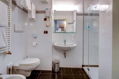 a white bathroom with a toilet and a sink at Art & Hotel Aeroporto in Stezzano