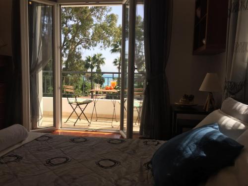 a bedroom with a bed and a sliding glass door at Deluxe First Line Villa in Pervolia