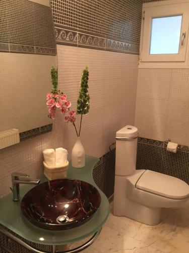 a bathroom with a sink and a toilet at Deluxe First Line Villa in Pervolia