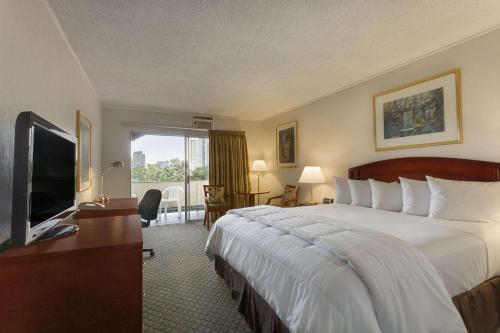 um quarto de hotel com uma cama grande e uma televisão em Days Inn by Wyndham San Diego/Downtown/Convention Center em San Diego