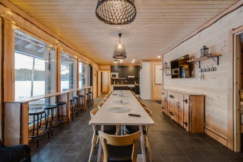 une salle à manger avec une grande table et des chaises dans l'établissement Evon Luonto - Aulangon Rantahuvila, à Hämeenlinna