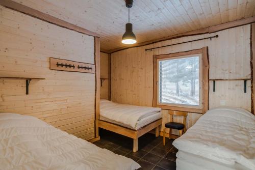 a room with two beds and a window in it at Evon Luonto - Aulangon Rantahuvila in Hämeenlinna
