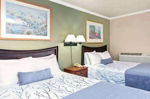 a hotel room with two beds and a telephone at Days Inn by Wyndham San Jose Convention Center in San Jose