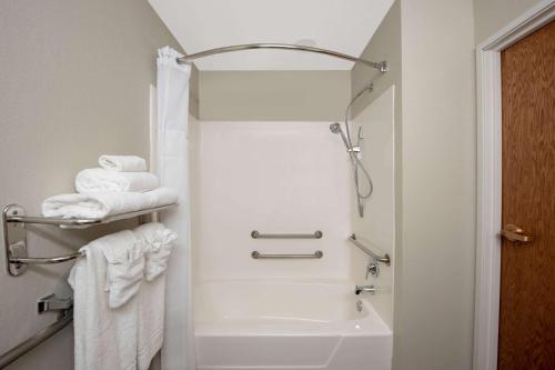 a bathroom with a shower and a bath tub with towels at Microtel Inn & Suites by Wyndham Springfield in Springfield