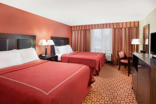 a hotel room with two beds and a flat screen tv at Super 8 by Wyndham Chicago Northlake O'Hare South in Northlake