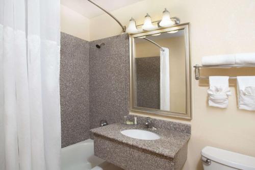 a bathroom with a sink and a toilet and a mirror at Super 8 by Wyndham Chicago Northlake O'Hare South in Northlake