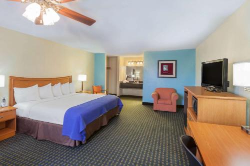een hotelkamer met een bed en een flatscreen-tv bij Days Inn by Wyndham Natchitoches in Natchitoches