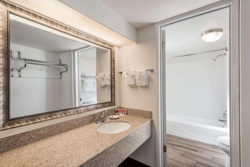 a bathroom with a sink and a mirror at Days Inn & Suites by Wyndham Lodi in Lodi