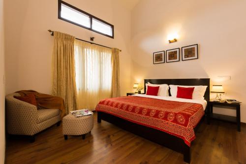 a hotel room with a bed and a chair at The Xanadu Birkenhead in Kodaikānāl