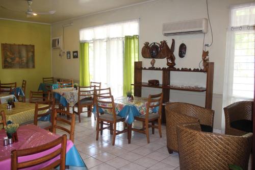 jadalnia ze stołami i krzesłami w restauracji w obiekcie Taklam Lodge And Tours w Kokopo