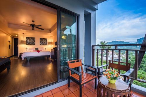 a bedroom with a bed and a balcony at Krabi Chada Resort - SHA Plus in Ao Nang Beach