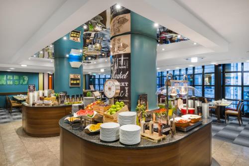 a buffet area of a restaurant with food on a counter at Mercure Budapest City Center in Budapest