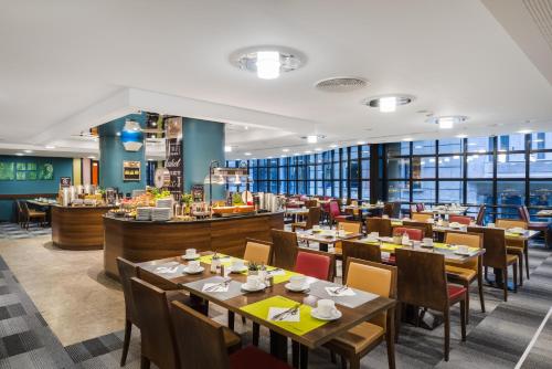a restaurant with tables and chairs and a cafeteria at Mercure Budapest City Center in Budapest