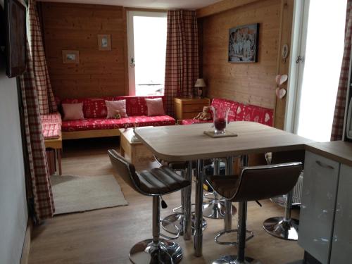 uma sala de estar com uma mesa e cadeiras e um sofá em Prariond 5 em Tignes