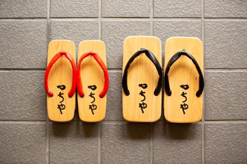 a pair of wooden slippers on a wall at TSUCHIYA Kinosaki onsen in Toyooka
