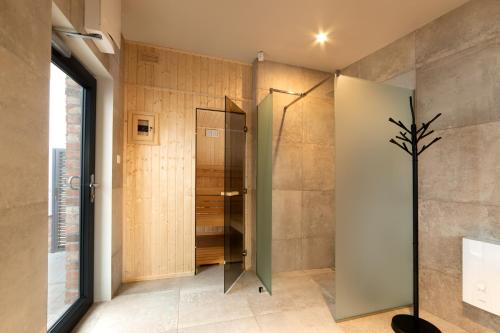 baño con ducha y puerta de cristal en Apartamenty Centrum Park, en Zielona Góra
