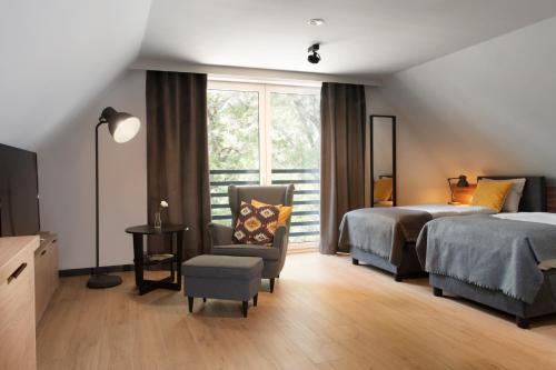 1 dormitorio con 2 camas, silla y ventana en Apartamenty Centrum Park, en Zielona Góra