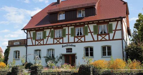 a large white building with a red roof at Haus Seefrieden in Uhldingen-Mühlhofen