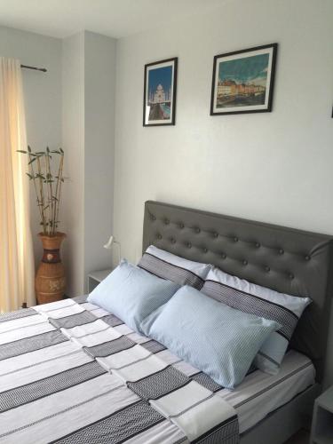 a bed in a bedroom with two pictures on the wall at Unit 1109 Cityscape Residences in Bacolod