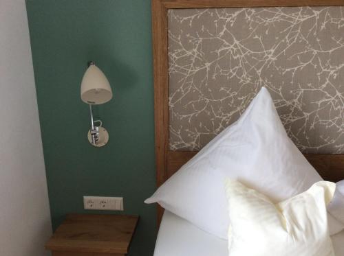 a bedroom with a bed with a headboard and a lamp at Haus Seefrieden in Uhldingen-Mühlhofen