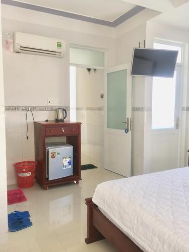 a bedroom with a bed and a tv in it at NGỌC QUÝ Mini House in Quy Nhon