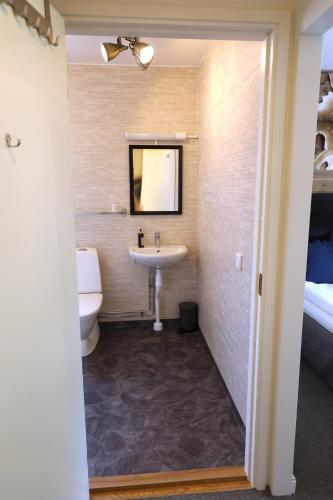 a bathroom with a sink and a toilet and a bed at Kosta Lodge in Kosta