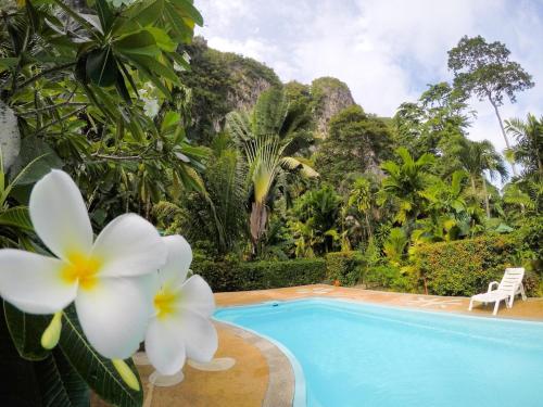 a villa with a swimming pool and flowers at Vipa Tropical Resort in Ao Nang Beach