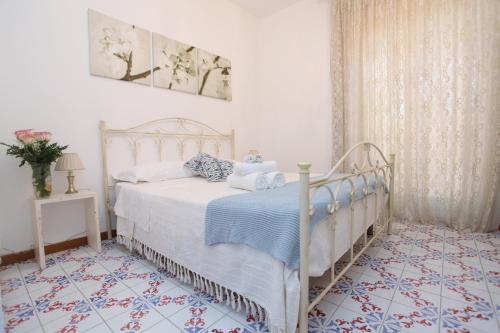 サン・レオーネにあるB&B Villa Maiolicaのベッドルーム(白と青のシーツが入った白いベッド付)