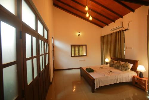a bedroom with a bed and a large window at Kandyan Fo Rest in Kandy