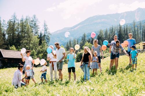a group of people standing in a field with balloons at Pitzis Kinderhotel - Family Only in Arzl im Pitztal