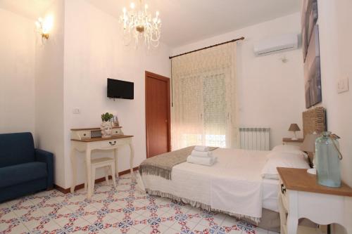 a bedroom with a bed and a table and a chair at B&B Villa Maiolica in San Leone