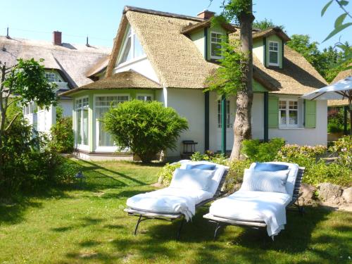 two lounge chairs in front of a house at Das Gut klein Bollhagen in Wittenbeck